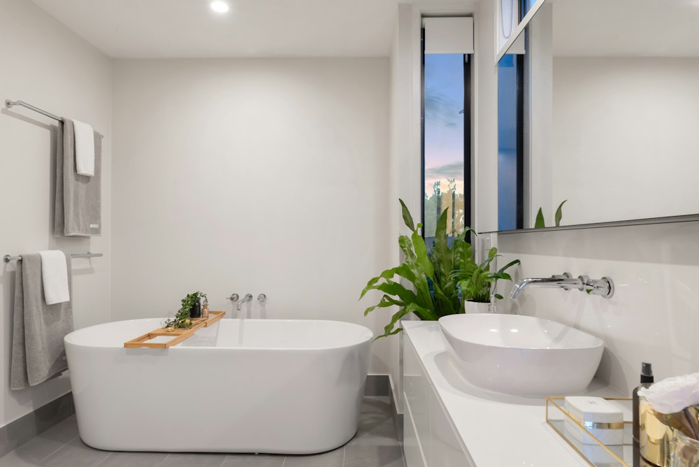 Bright bathroom with a basin, mirror and bathtub